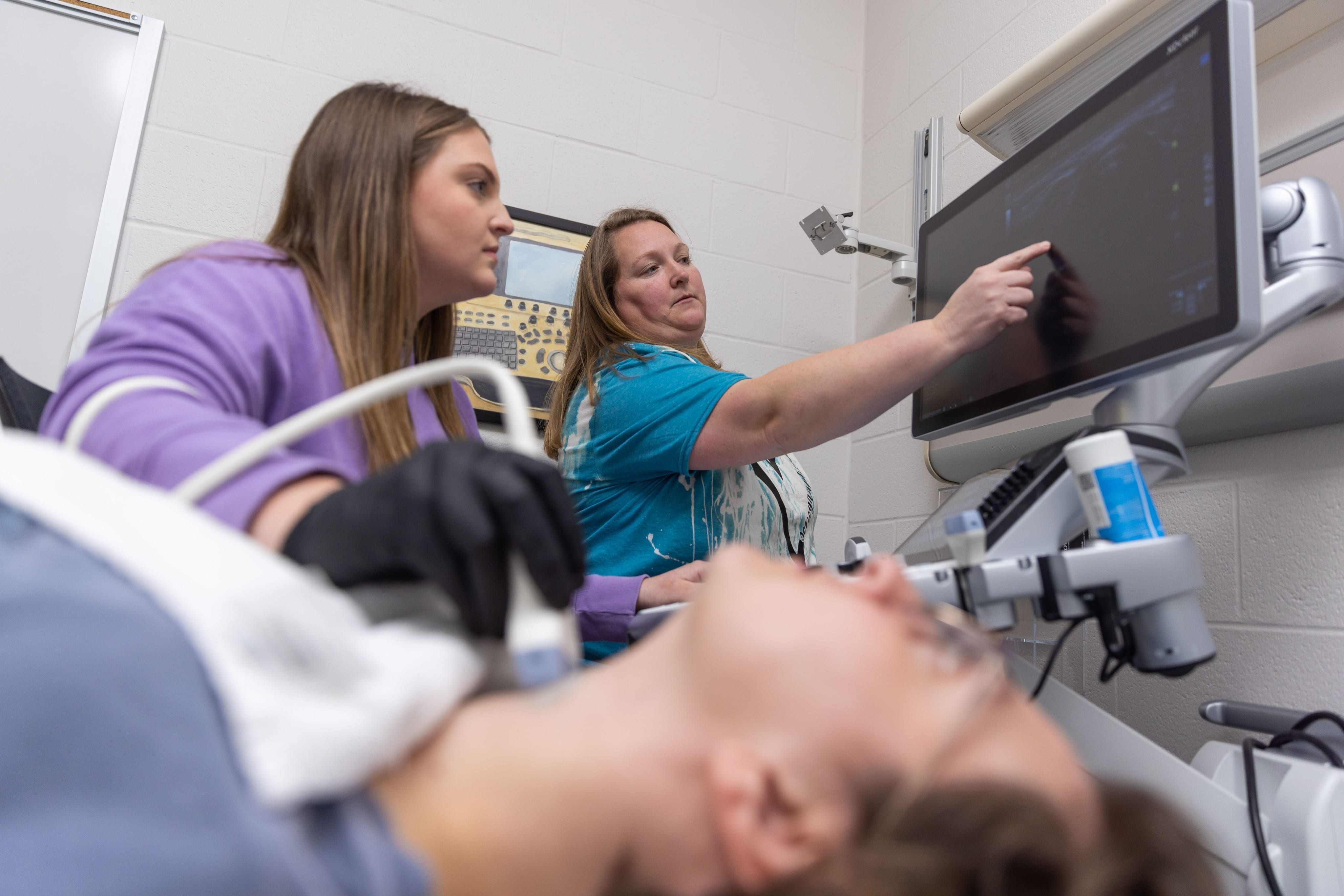 A sonography student using medical imaging equipment
