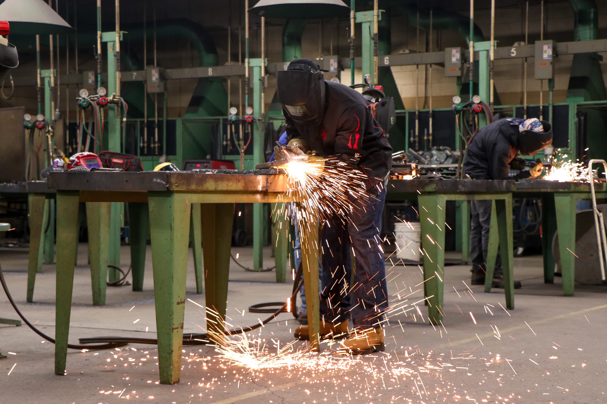 A welding student practicing in a lab